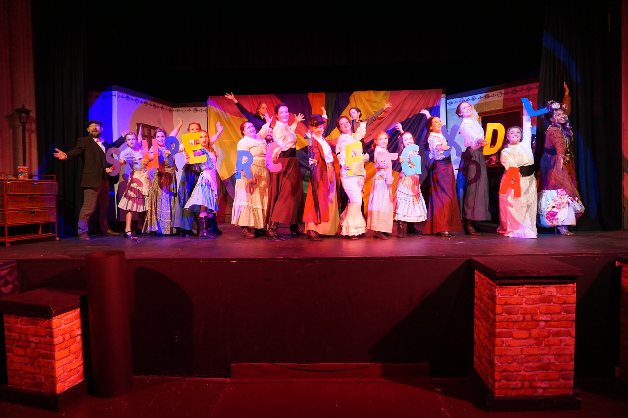 Ensemble performing under stage lights at a Rooted Gypsy Repertoire show
